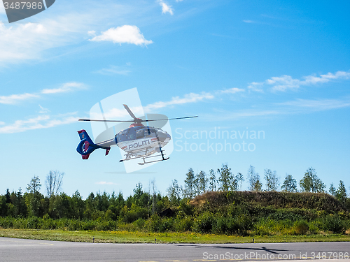 Image of Police helicopter from norwegian authorities hoovering over land