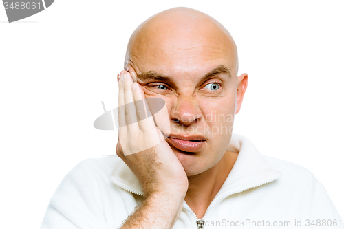 Image of man holding his hand to his cheek. Toothache or problem