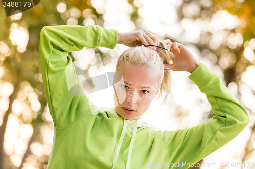 Image of Confident sporty woman wearing fashionable green hoodie. 