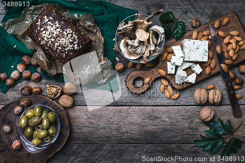 Image of Rustic style olives, nuts mushrooms  and bread  with seeds