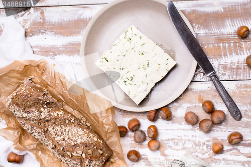 Image of cheese with dill and bread huzelnuts on wooden board