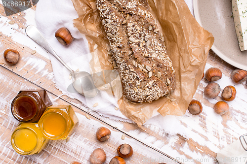 Image of Bread with honey huzelnuts and cheese on board