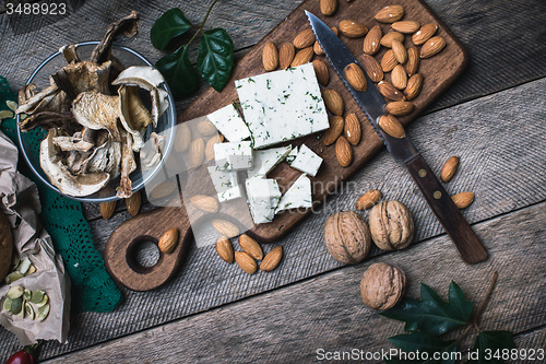 Image of Cheese with dill, nuts mushrooms  and on wooden table