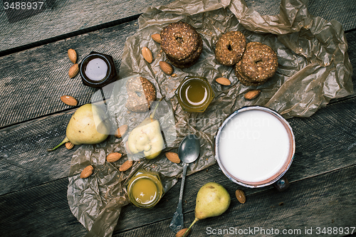 Image of Tasty Pears almonds Cookies and milk on rustic wood