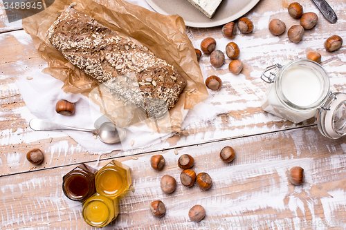 Image of Bread with honey huzelnuts and cheese on wooden board