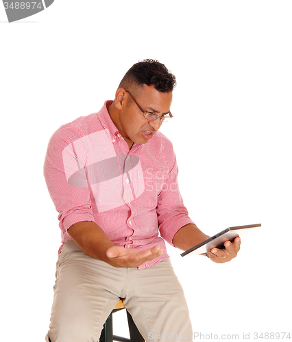Image of Man angry at his tablet computer.