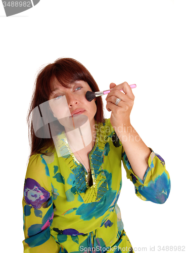 Image of Woman putting on makeup.