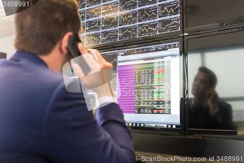 Image of Stock trader looking at computer screens.