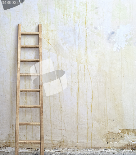 Image of weathered stucco wall with wooden ladder