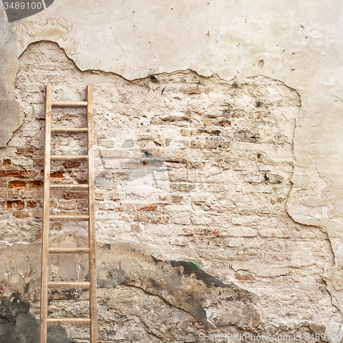 Image of weathered stucco wall with wooden ladder