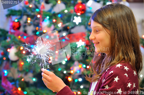 Image of Portrait of cute girl looking at fire sparks.