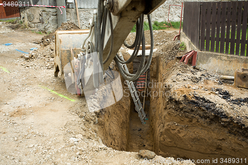 Image of excavator ploughshare on trench - constructing canalization