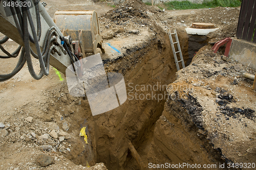 Image of excavator ploughshare on trench - constructing canalization