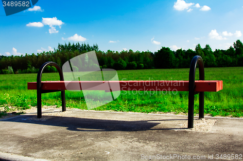 Image of wooden bench. field