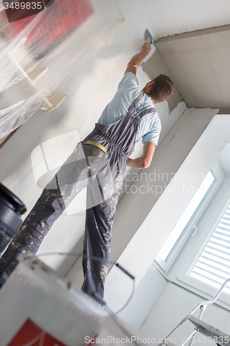 Image of Plasterer renovating indoor walls and ceilings.