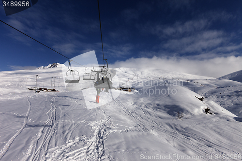 Image of Chair-lift and off-piste slope in sun day