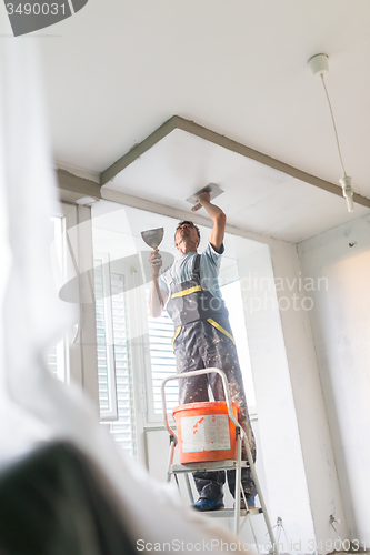 Image of Plasterer renovating indoor walls and ceilings.