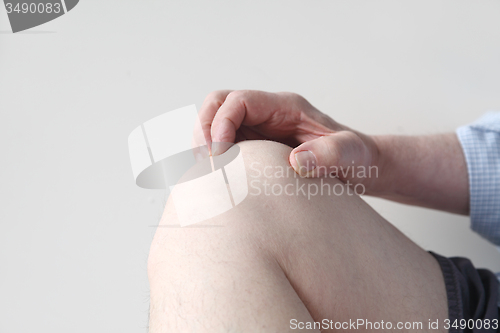 Image of man grasps his sore knee