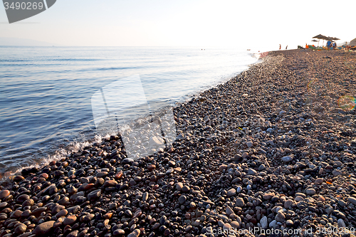 Image of stone in the coastline sunrise and parasol