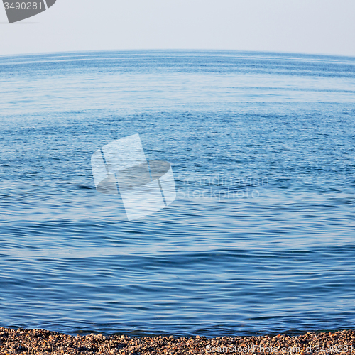 Image of stone in the coastline sunrise and light ocean white sky