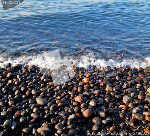 Image of stone in the coastline sunrise and light ocean white sky