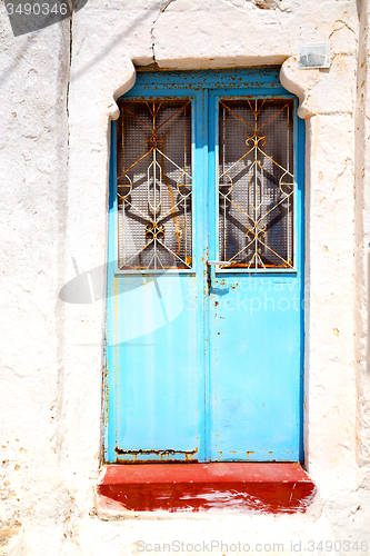 Image of blue door in antique village santorin   white wall