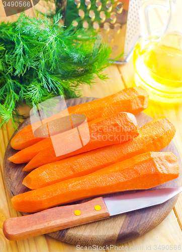 Image of raw carrots and knife on the wooden board