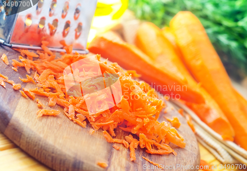 Image of raw carrots and knife on the wooden board