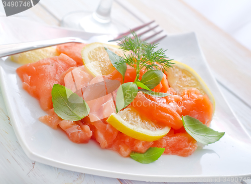 Image of fresh salmon with lemon on the white plate