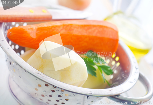 Image of Raw potato and carrot in the metal bowl