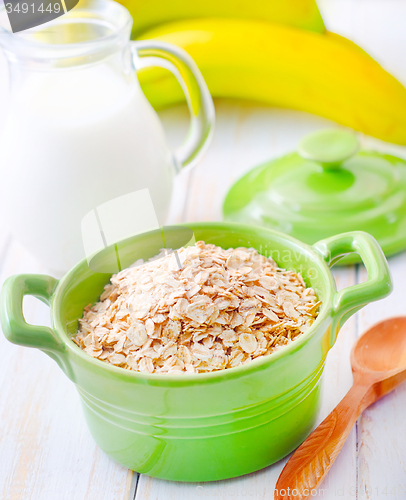 Image of Oat flakes in the green bowl with banana and milk