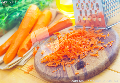 Image of raw carrots and knife on the wooden board