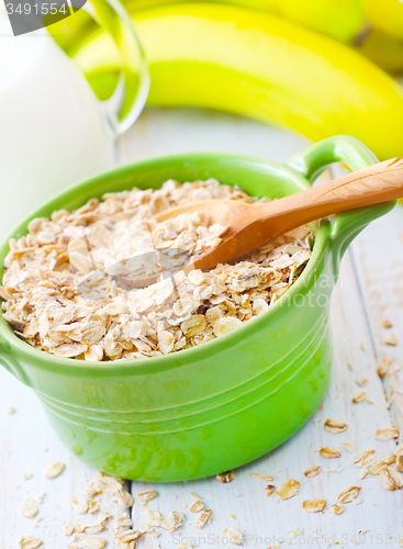 Image of Oat flakes in the green bowl with banana and milk