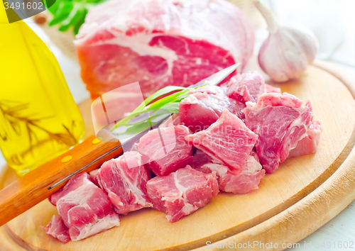 Image of raw meat and knife on the wooden board