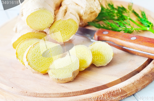 Image of Fresh ginger and knife on the wooden board