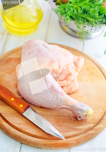 Image of Raw chicken and knife on the wooden board