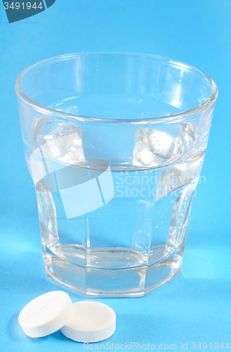 Image of white pills and water