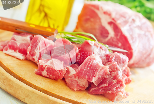 Image of raw meat and knife on the wooden board