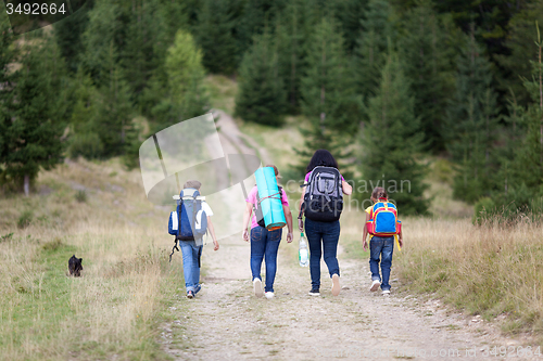 Image of Family walk with backpacks from back