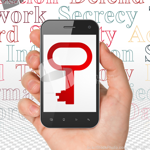 Image of Safety concept: Hand Holding Smartphone with Key on display