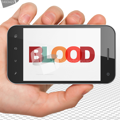 Image of Health concept: Hand Holding Smartphone with Blood on  display