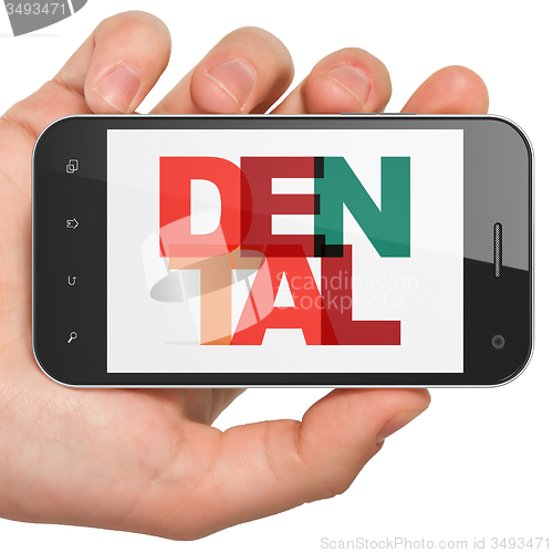 Image of Medicine concept: Hand Holding Smartphone with Dental on  display