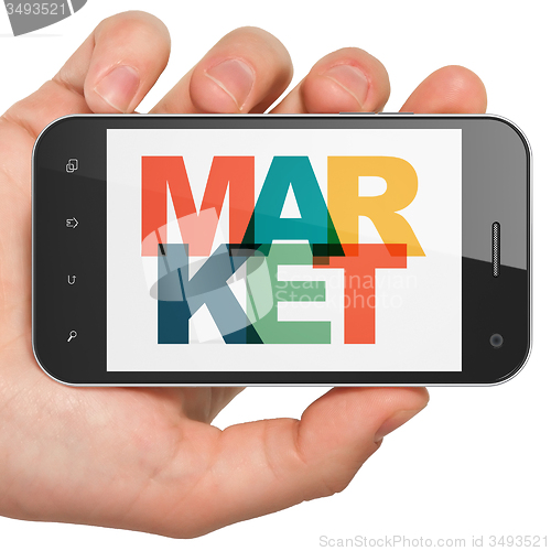 Image of Marketing concept: Hand Holding Smartphone with Market on  display