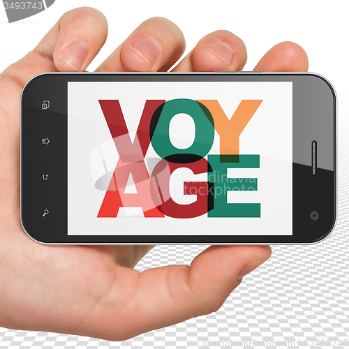 Image of Tourism concept: Hand Holding Smartphone with Voyage on  display