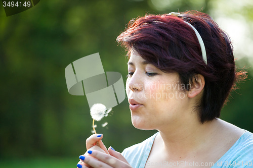 Image of Woman Blowing Dandelion
