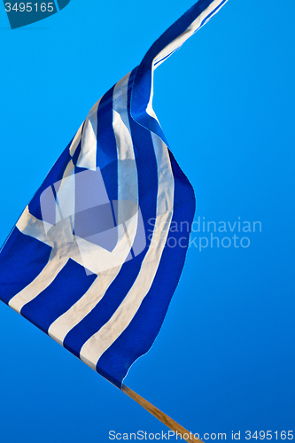 Image of waving greece flag in the blue sky and flagpole