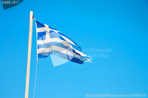 Image of waving   flag in   blue sky and flagpole