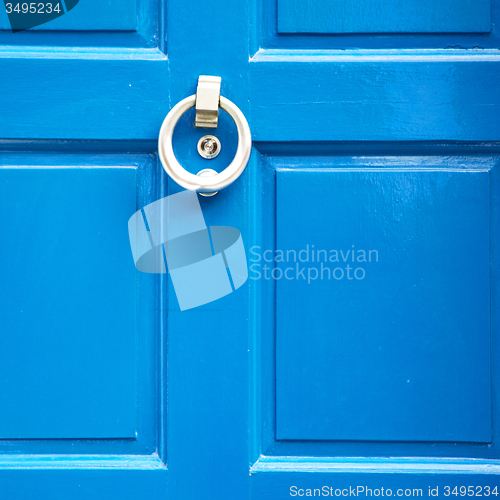 Image of  blue handle in london antique brown door  rusty  brass nail and