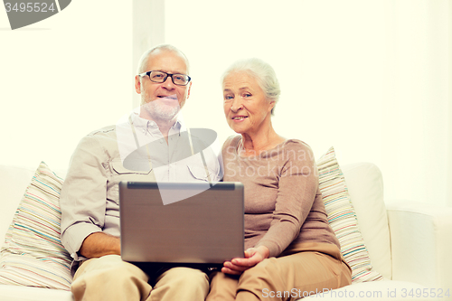 Image of happy senior couple with laptop at home