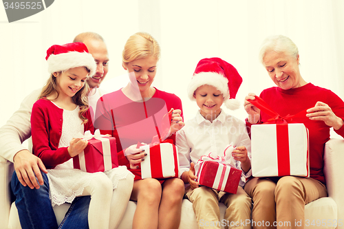 Image of smiling family with gifts at home